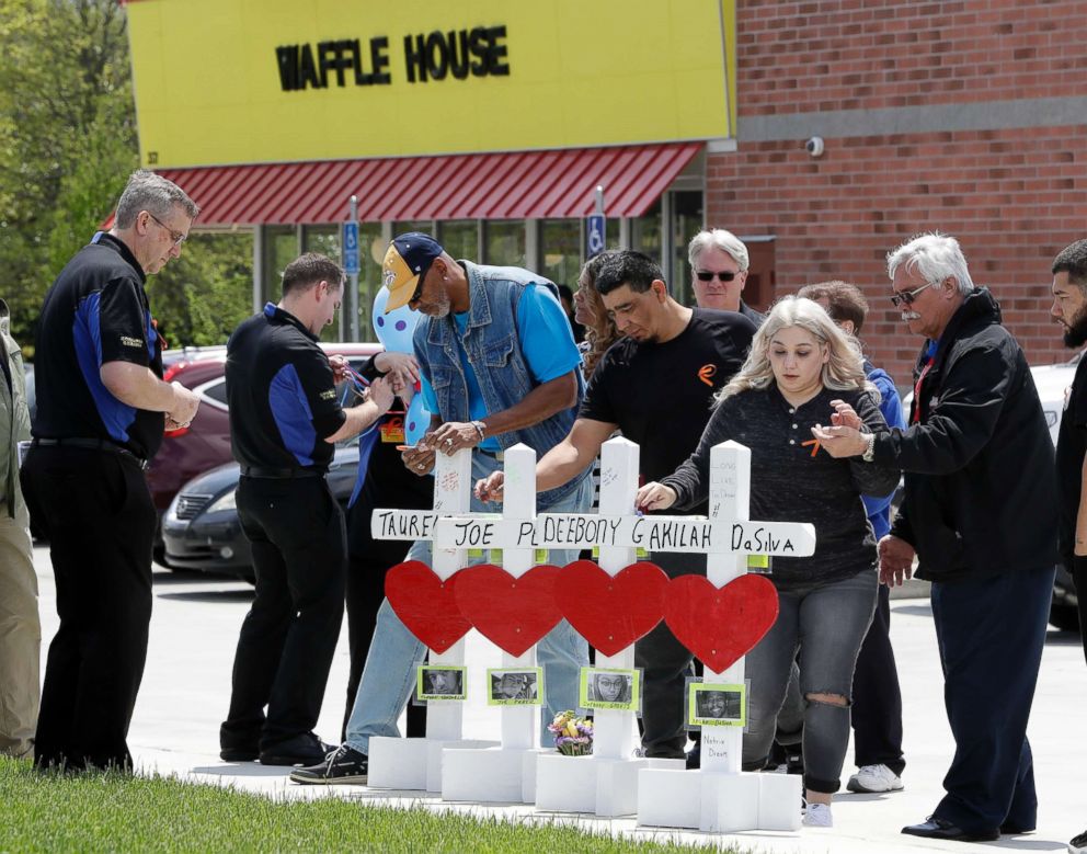 PHOTO: Family members of people killed at a Waffle House restaurant write messages on wooden crosses set up as a memorial, April 25, 2018, in Nashville, Tenn. 