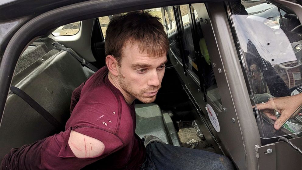 In this photo released by the Metro Nashville Police Department, Travis Reinking sits in a police car after being arrested in Nashville, Tenn., on April 23, 2018.