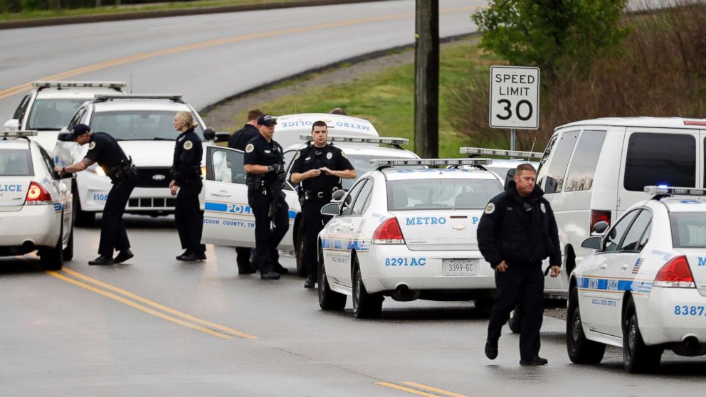 PHOTO: Nashville police officers gather alongside a wooded area as they search for a shooting suspect near a Waffle House restaurant, April 22, 2018, in Nashville, Tenn. 