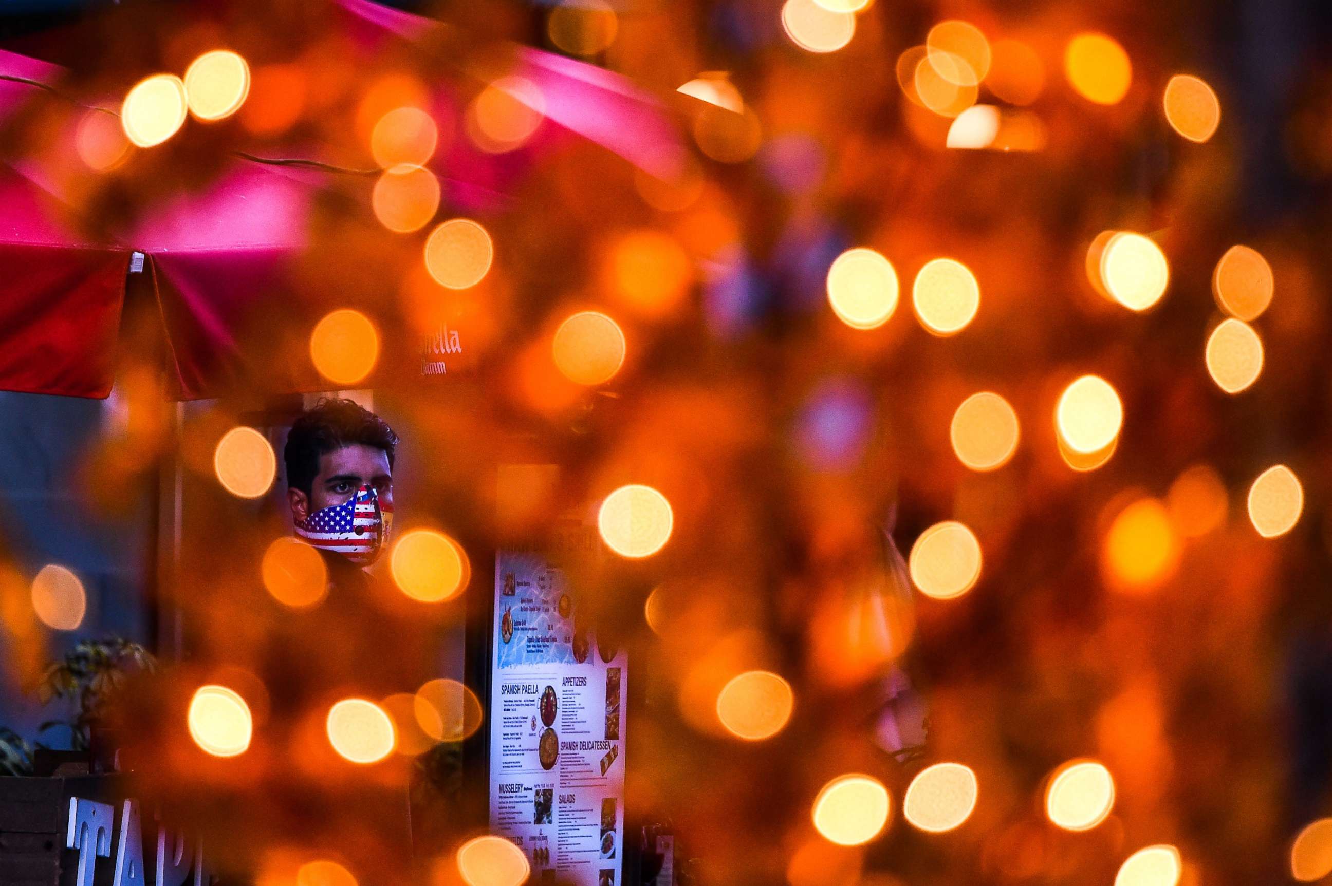 PHOTO: A waiter wears a face mask outside a restaurant at a shopping center in Miami Beach, Florida, on June 29, 2020.