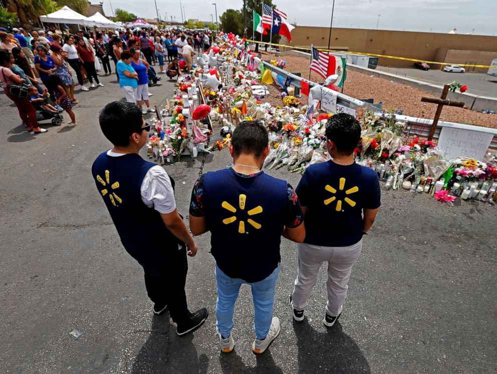 PHOTO: Three Walmart employees pause while visiting the make shift memorial after the mass shooting that happened at a Walmart in El Paso, Texas, Aug. 6, 2019.