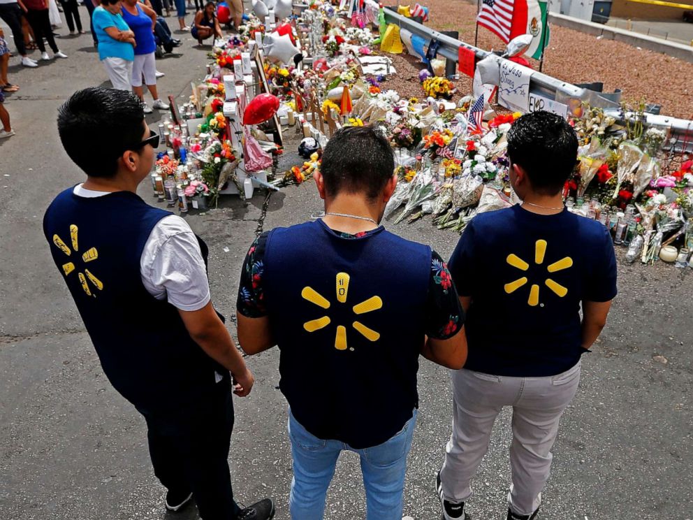 PHOTO: Three Walmart employees pause while visiting the make shift memorial after the mass shooting that happened at a Walmart in El Paso, Texas, Aug. 6, 2019.