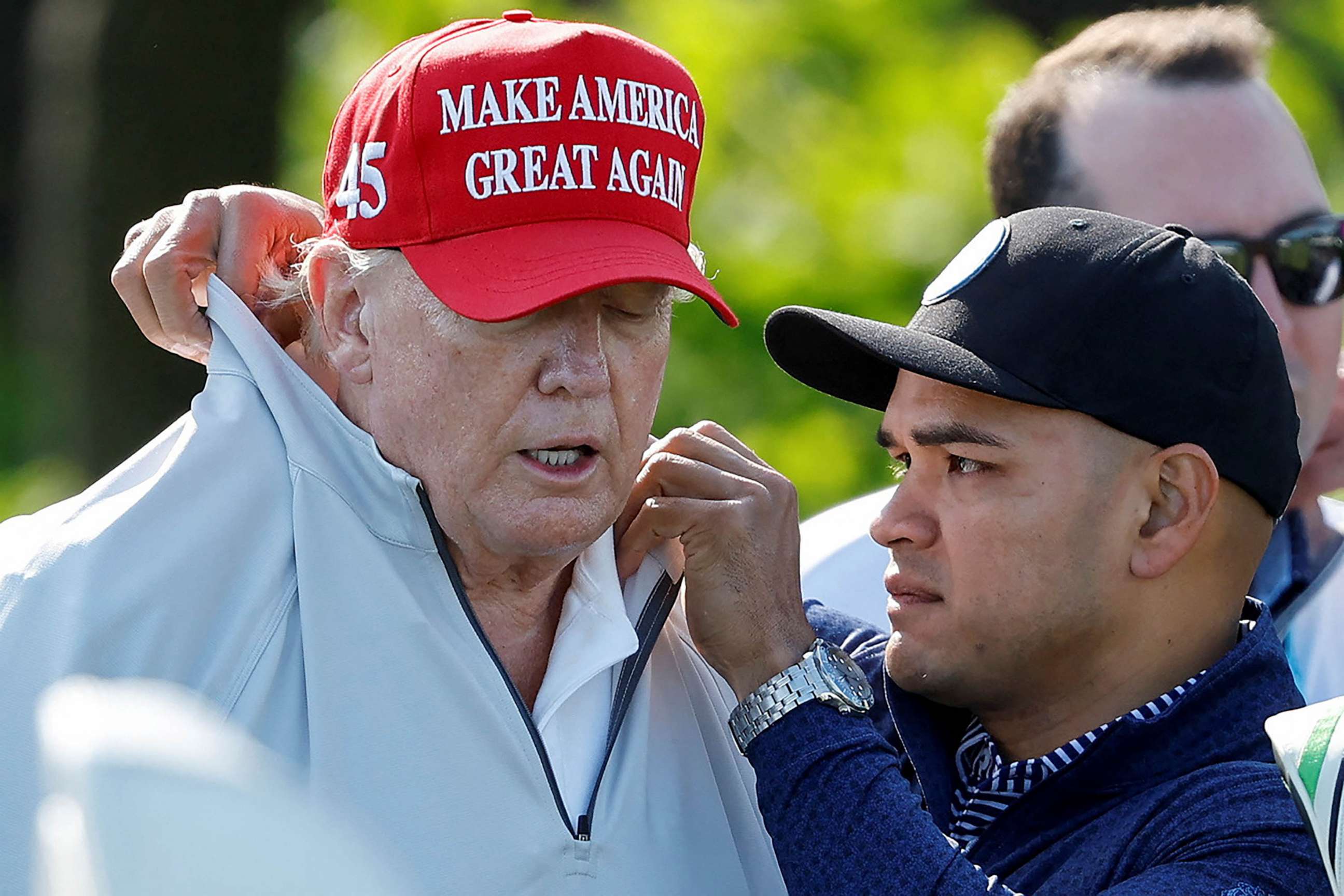 PHOTO: FILE - Walt Nauta, personal aide to former U.S. President Donald Trump who faces charges of being Trump's co-conspirator in the alleged mishandling of classified documents, fixes Trump's collar before a LIV Golf Pro-Am golf tournament