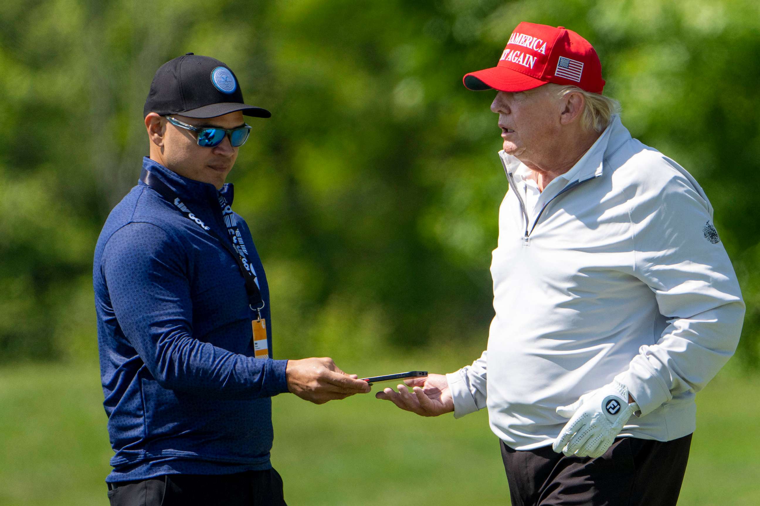 PHOTO: FILE - Walt Nauta takes a phone from former President Donald Trump during the LIV Golf Pro-Am at Trump National Golf Club, May 25, 2023, in Sterling, Va.