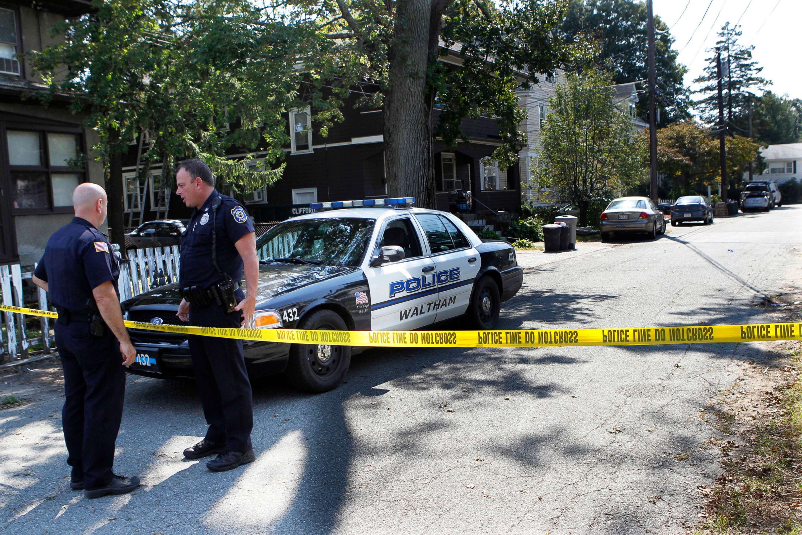 PHOTO: In this Sept. 13, 2011, file photo, police remain at an outpost on Harding Ave., in Waltham, Mass., after three men were found dead the previous day in the yellow house at center, behind the trash cans.