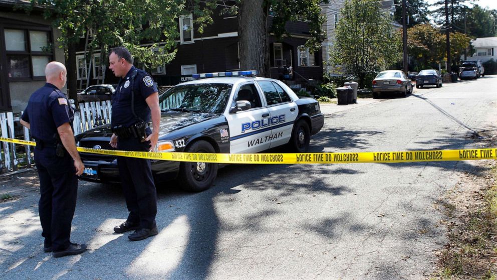 PHOTO: In this Sept. 13, 2011, file photo, police remain at an outpost on Harding Ave., in Waltham, Mass., after three men were found dead the previous day in the yellow house at center, behind the trash cans.
