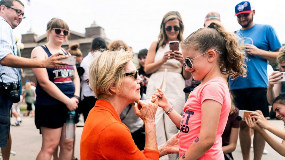 PHOTO: Democratic candidate for President Sen. Elizabeth Warren does a pinky swear with a little girl at the Iowa State Fair in Des Moines, Iowa on Aug. 10, 2019.