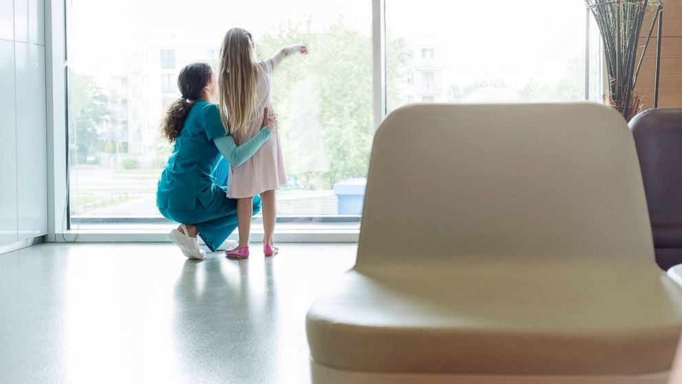 PHOTO: A nurse looks on as a girl points out of a waiting room window in this undated file photo.