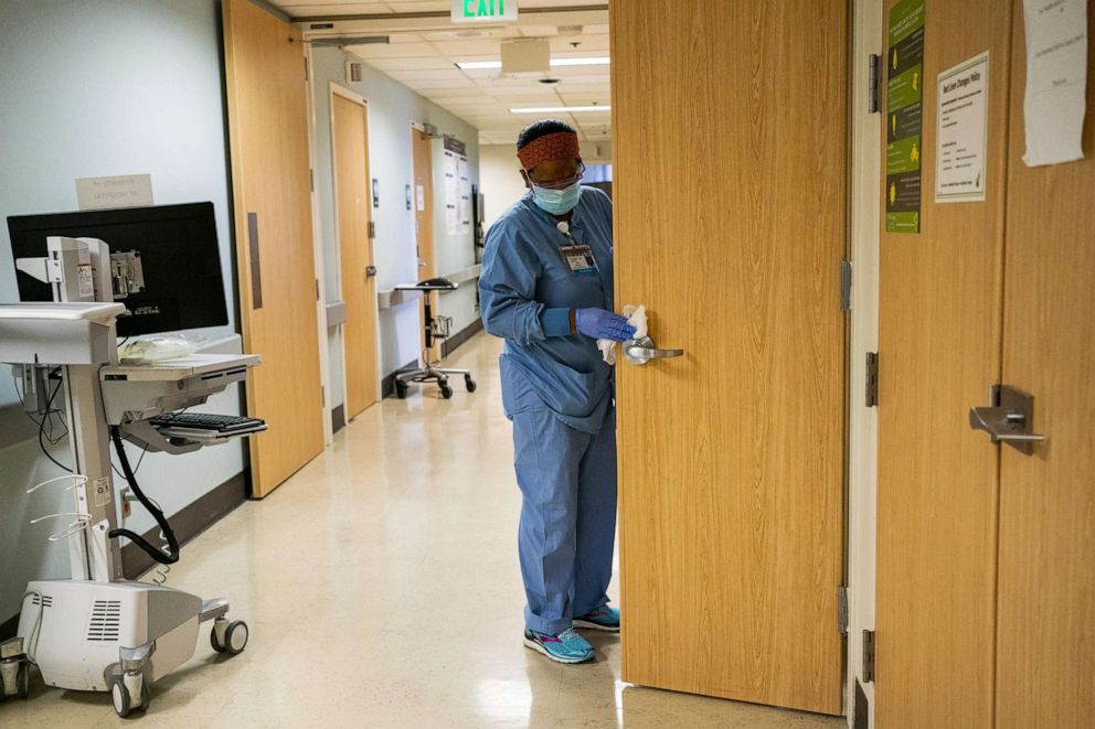 PHOTO: Aster Mekonen disinfects a door handle during her cleaning shift at Harborview Medical Center, Aug. 20, 2020, in Seattle.
