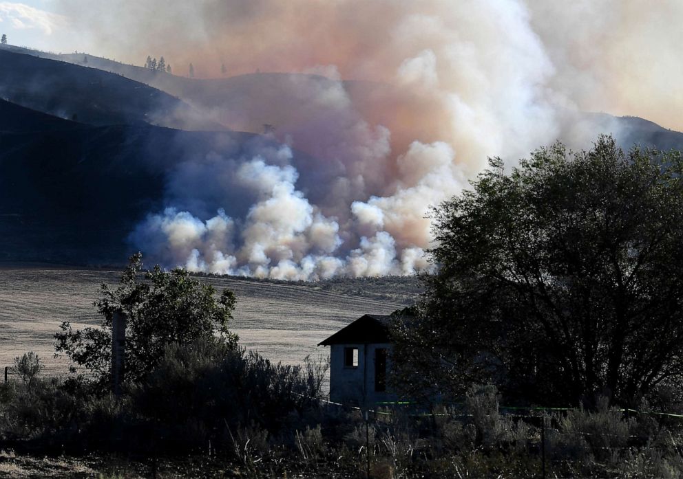 PHOTO: Late afternoon light catches smoke from the Cold Springs Canyon Pearl Hill Fire near a structure that appeared to be empty long before the fire, Monday, Sept. 7, 2020, near Omak, Wash.