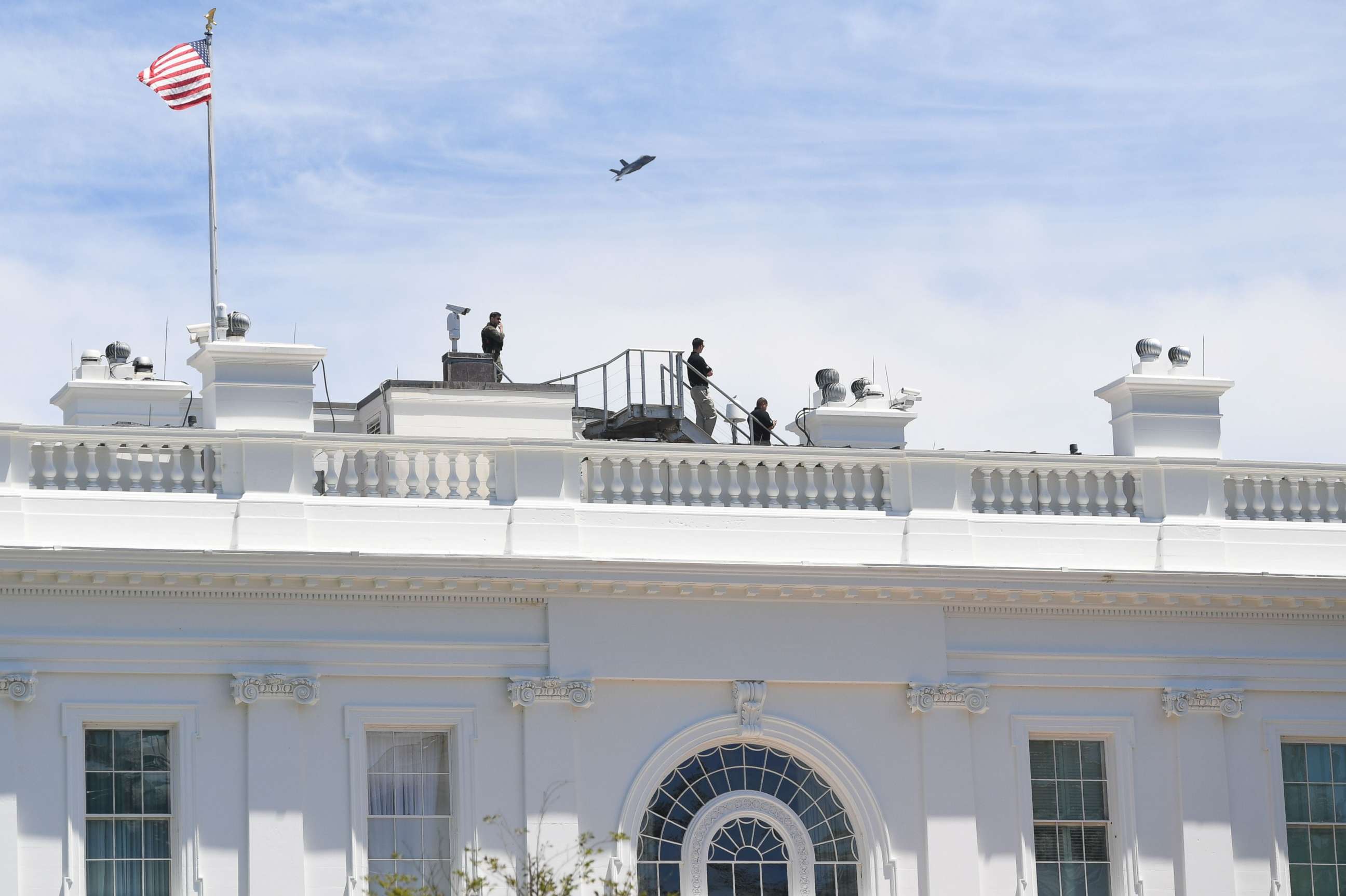 PHOTO: Security watch as a F-35 fighter plane flies over the White House on June 12, 2019, in Washington.