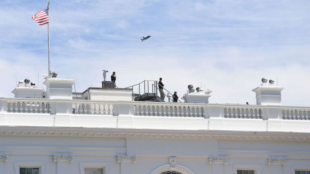 PHOTO: Security watch as a F-35 fighter plane flies over the White House on June 12, 2019, in Washington.