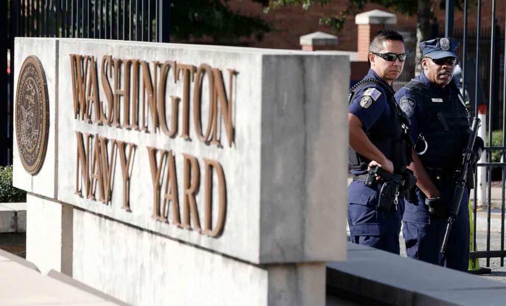 PHOTO: A Washington, D.C. Metropolitan police officer and a Naval District Washington policemen stand guard at the main gate of the Washington Navy Yard in Washington, Sept. 17, 2013.