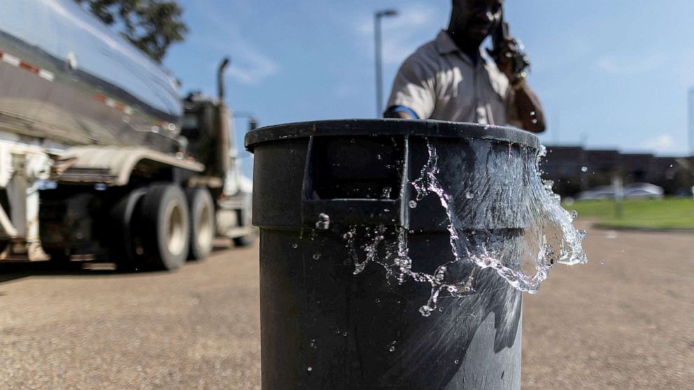 PHOTO: A bucket of non-potable water to be used for flushing the toilets at Forest Hill High School is pushed from a distribution tanker into the school's parking lot in Jackson, Mississippi, on 31 August 2022.