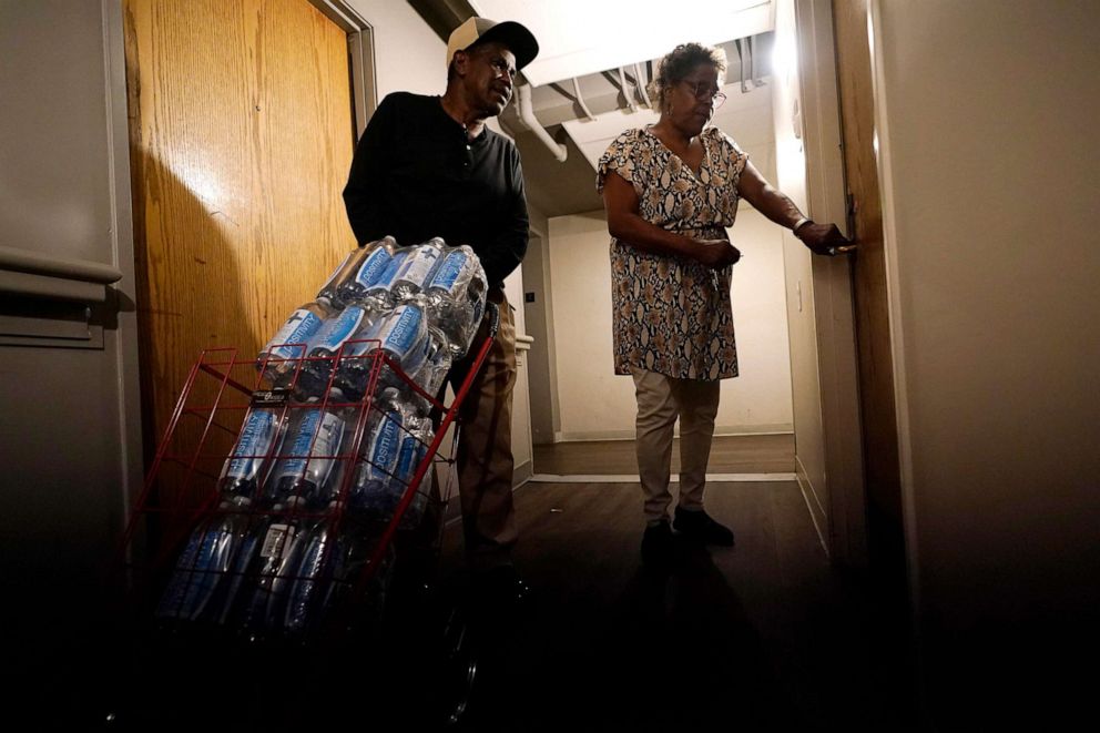 PHOTO: Friends help Golden Keys Senior Living apartments residents to transport cases of water in Jackson, Miss., Sept. 1, 2022. A recent flood worsened Jackson's longstanding water system problems. 