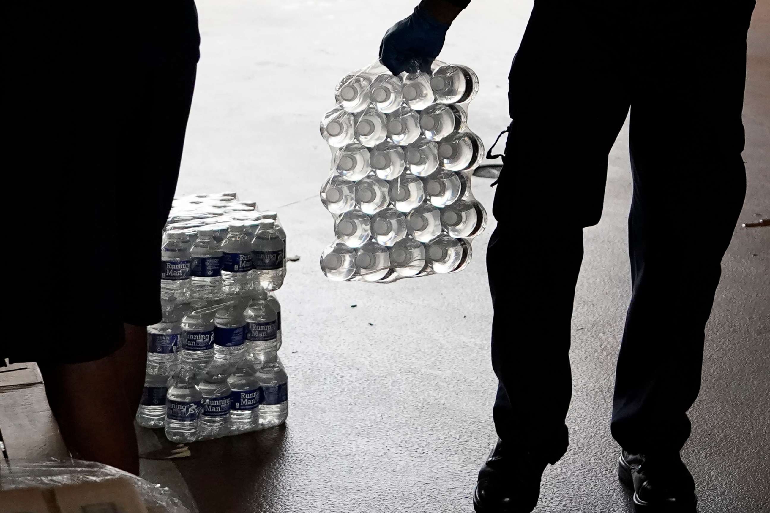 PHOTO: Bottled water is carried to a residents car by a recruit at the Fire Department in Jackson, Miss., Aug. 18, 2022. 