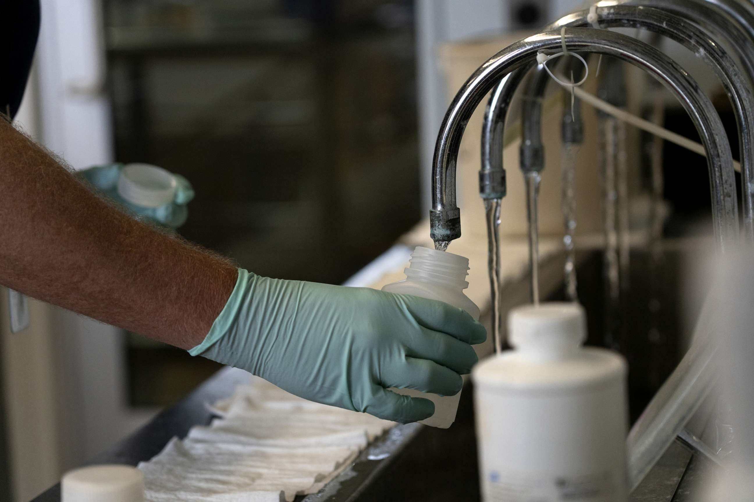 PHOTO: Geologist Ryan Bennett with the Illinois Environmental Protection Agency collects samples of treated Lake Michigan water in a laboratory at the water treatment plant in Wilmette, Illinois, July 3, 2021.