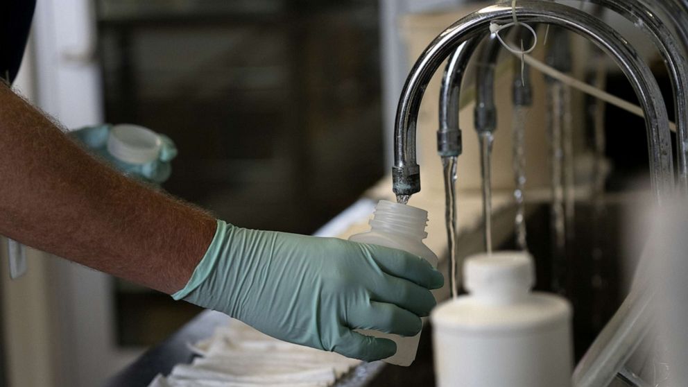 PHOTO: Geologist Ryan Bennett with the Illinois Environmental Protection Agency collects samples of treated Lake Michigan water in a laboratory at the water treatment plant in Wilmette, Illinois, July 3, 2021.