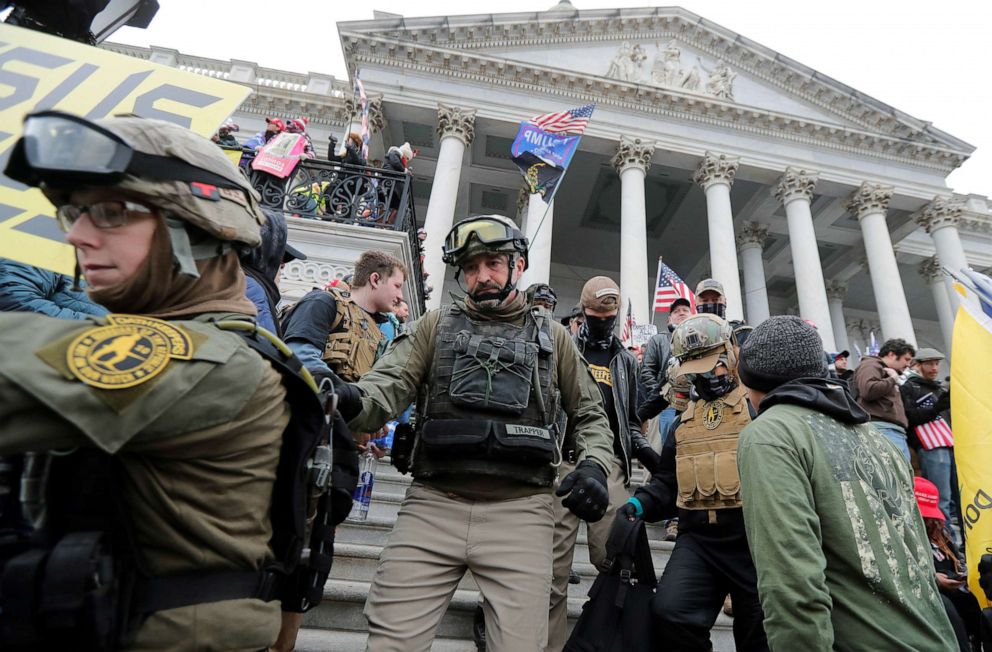 PHOTO: Jessica Marie Watkins, left, and Donovan Ray Crowl, center, both from Ohio, march down the East front steps of the Capitol with the Oath Keepers militia group in Washington, Jan. 6 2021. 