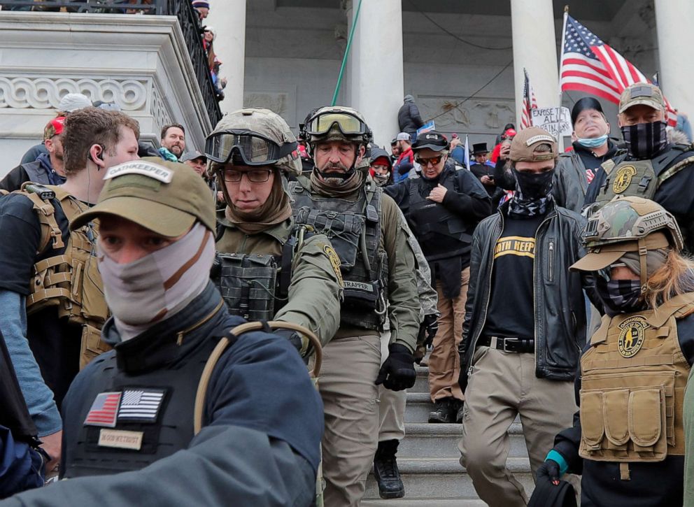 PHOTO: Jessica Marie Watkins, 2nd from left, and Donovan Ray Crowl, center, both from Ohio, march down the east front steps of the U.S. Capitol with members of the Oath Keepers militia group in Washington, Jan. 6, 2021.