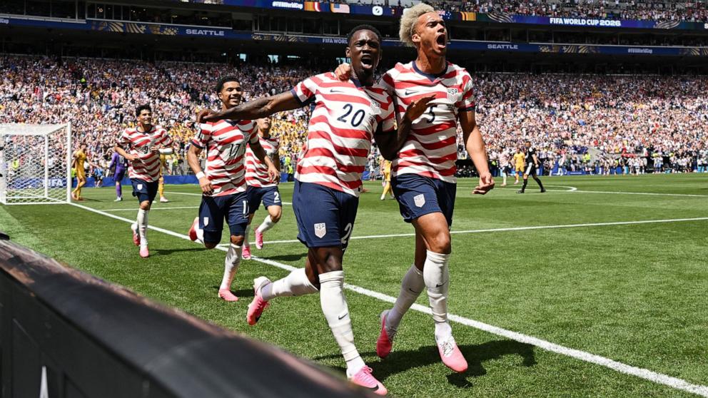 PHOTO: Folarin Balogun and Antonee Robinson of the USA celebrate after Australia's Cameron Burgess scores an own goal during their FIFA World Cup 2026 Group D match, June 19, 2026 in Seattle, Washington.