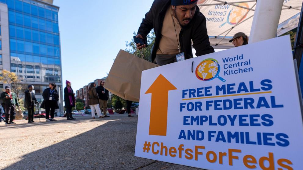 PHOTO: A person gets a bottle of water to go with a meal distributed by chef Jose Andres' World Central Kitchen for federal workers and their families in Canal Park, Oct. 27, 2025, in Washington.