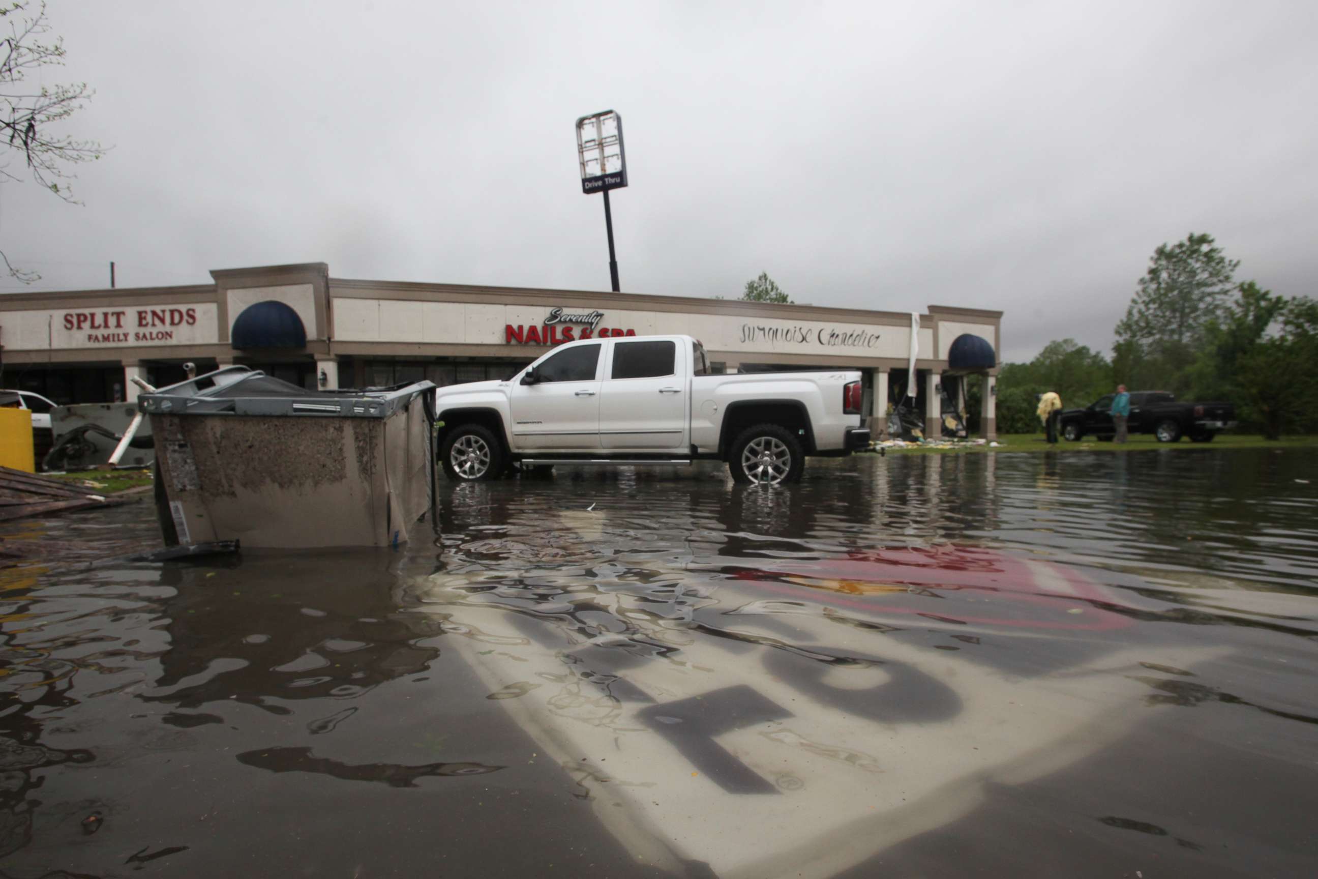 PHOTO: Debris is strewn in flooded water in the Pemberton Quarters strip mall following severe weather, April 13, 2019, in Vicksburg, Miss. 