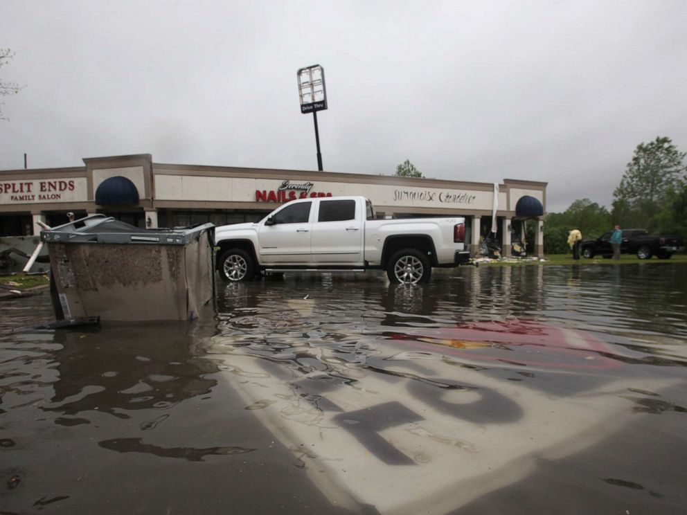 PHOTO: Debris is strewn in flooded water in the Pemberton Quarters strip mall following severe weather, April 13, 2019, in Vicksburg, Miss.