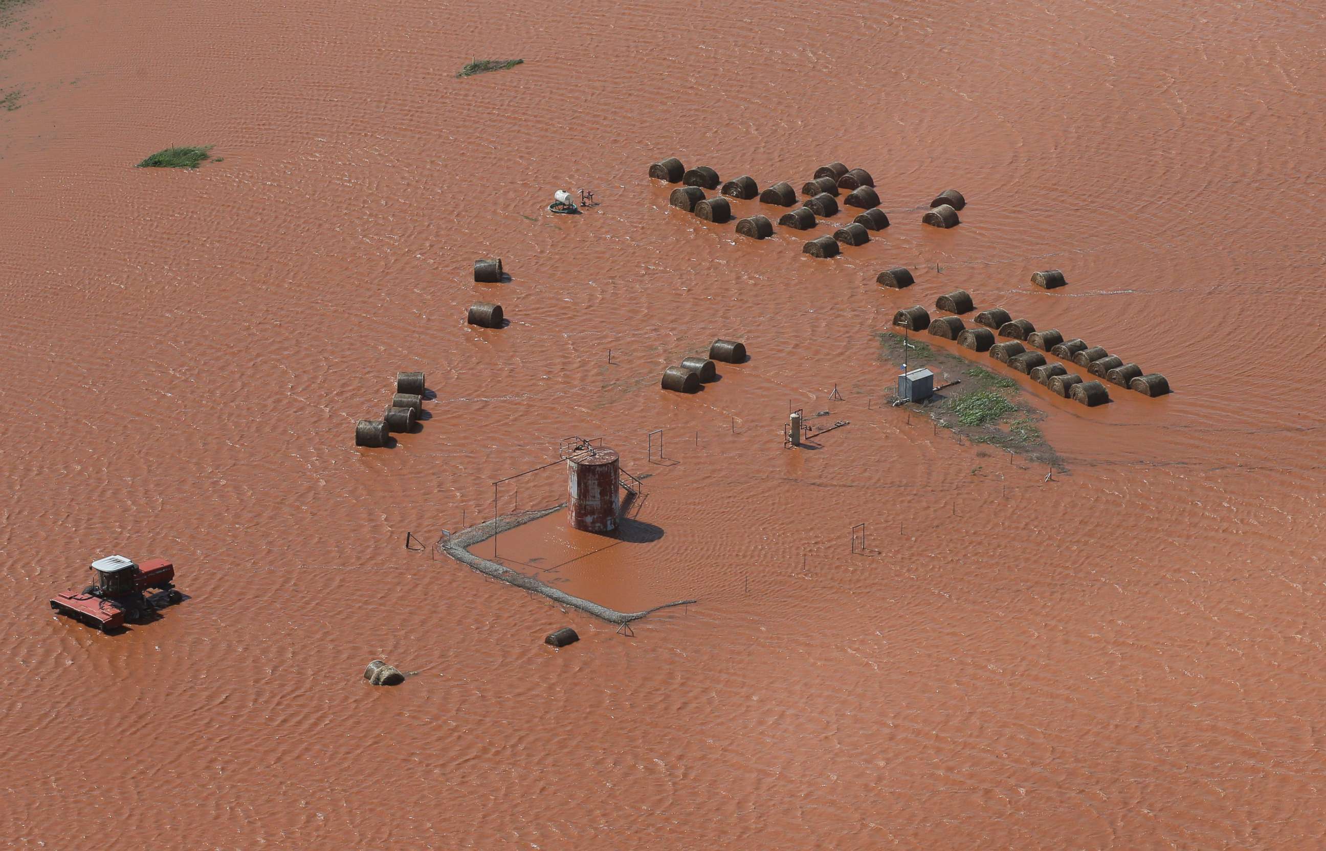 PHOTO: Hay bales and equipment are pictured in a flooded field, May 21, 2019, in Kingfisher, Okla. Flooding following heavy rains was an issue across the state. 