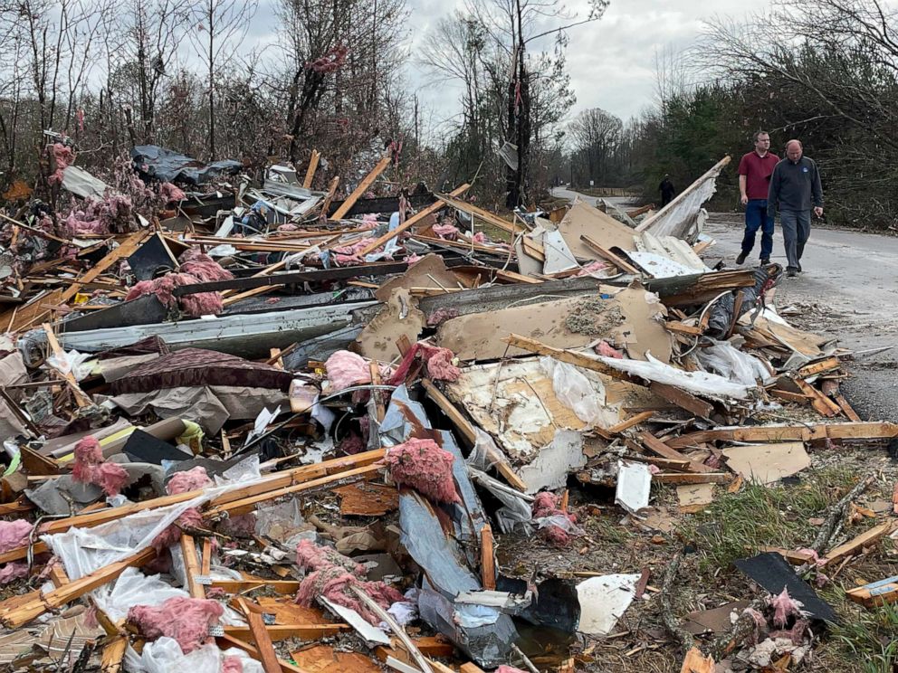 PHOTO: People walk through an area of destroyed structures in Flatwood, Ala., Nov. 30, 2022. 