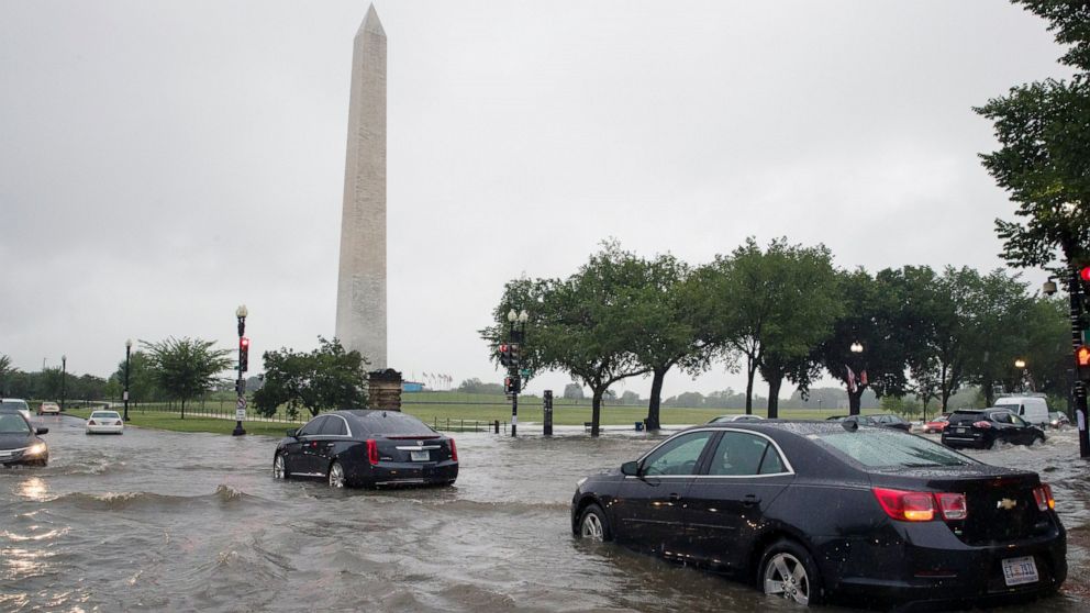 PHOTO: Heavy rainfall flooded the intersection of 15th Street and Constitution Ave., NW stalling cars in the street, Monday, July 8, 2019, in Washington near the Washington Monument.
