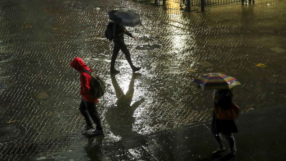 PHOTO: Evening commuters make their way across Wall and Broad Street in the rain, Oct. 16, 2019, in New York.