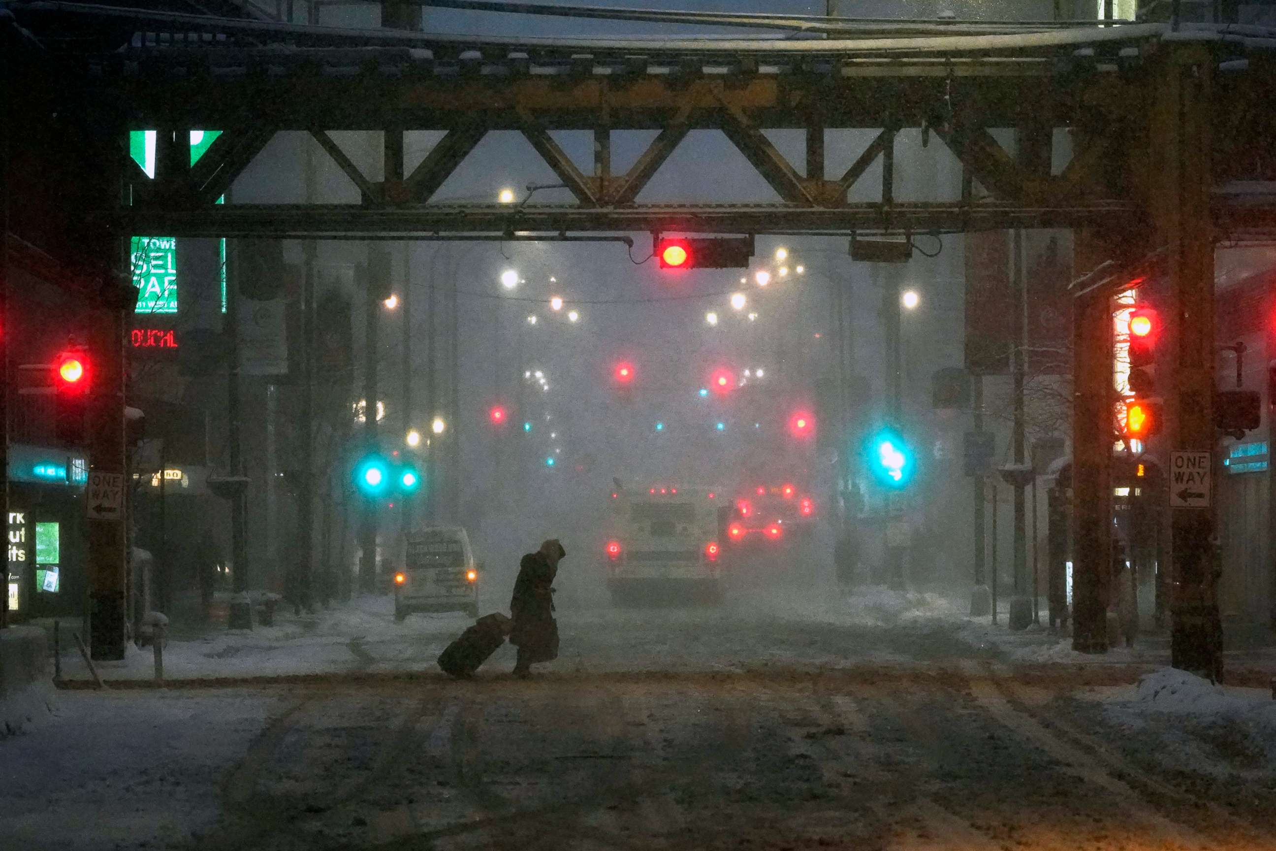 PHOTO: A pedestrian walks during falling snow  and slushy street conditions in Chicago, Feb. 2, 2022.