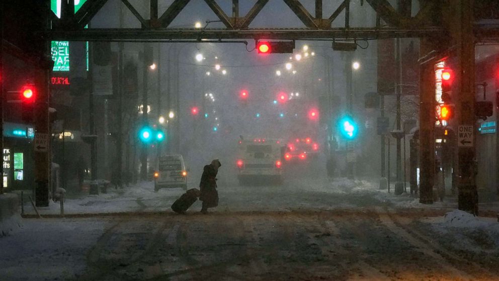 PHOTO: A pedestrian walks during falling snow  and slushy street conditions in Chicago, Feb. 2, 2022.