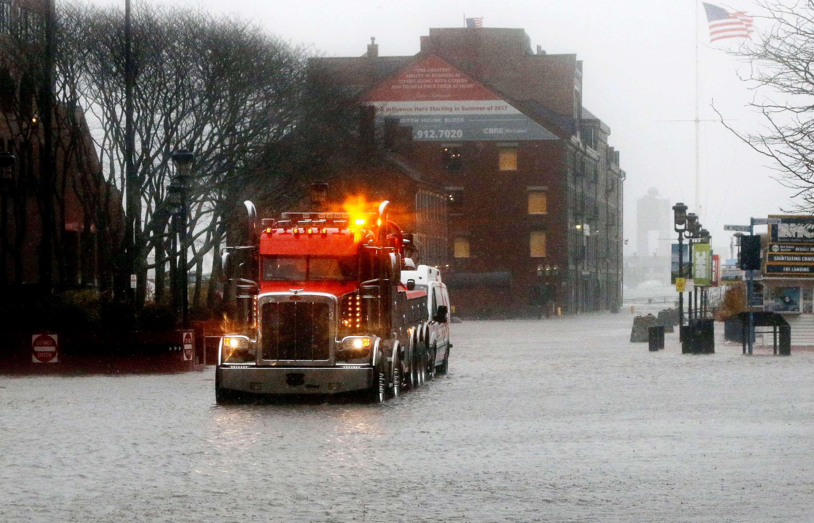 PHOTO: A wrecker tows a vehicle stranded on State Street by water from Boston Harbor at high tide, March 2, 2018, in Boston.