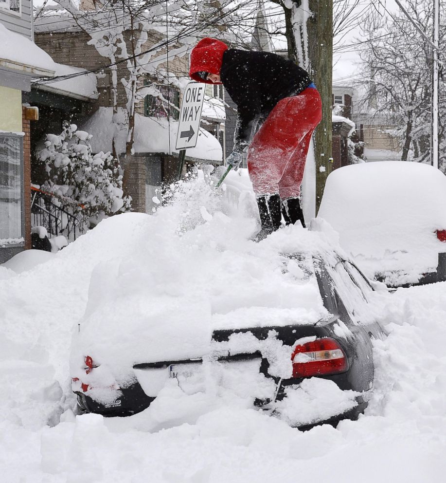 PHOTO: Soledda Hernandez stands on the roof of her car as she brushes off snow in Erie, Pa., Dec. 27, 2017. Snow continues to fall in Erie and surrounding areas that already have seen a record amount of snow over the past few days.