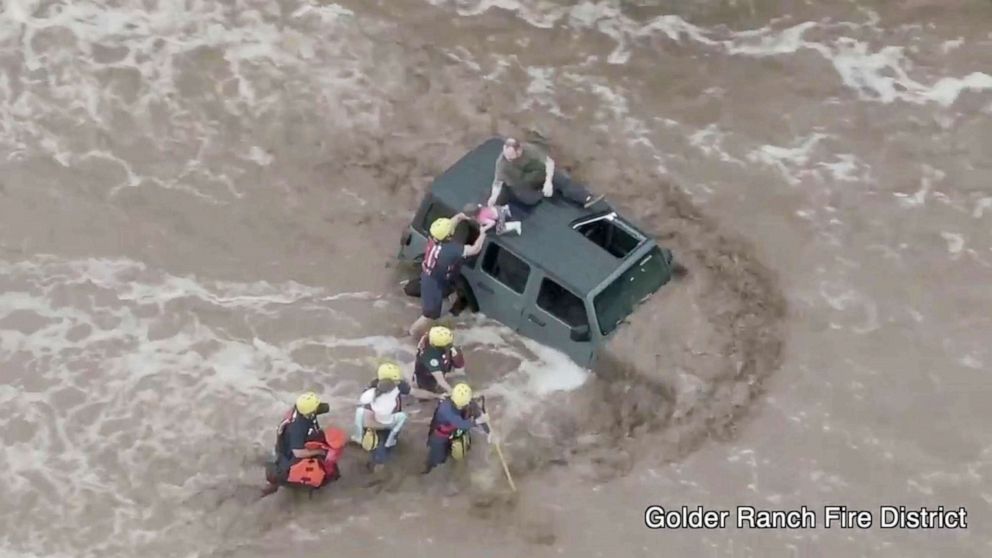 PHOTO: Firefighters rescue a man and two young girls who were stranded after their vehicle was washed away in flash floods near Tucson, Ariz., July 14, 2021.