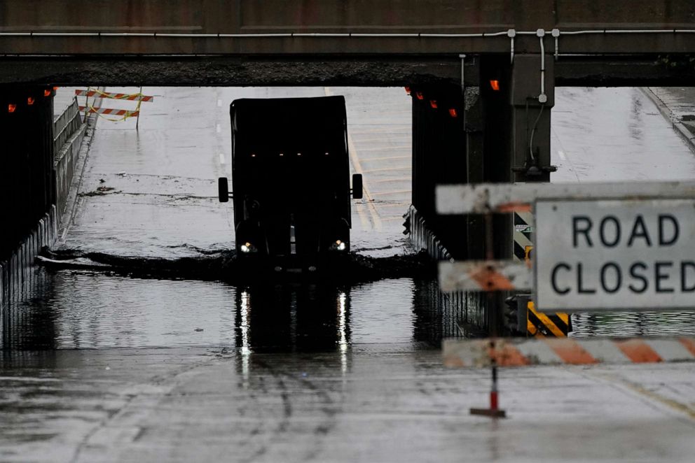 PHOTO: A semi-trailer drives through a flooded street in Detroit, July 16, 2021.