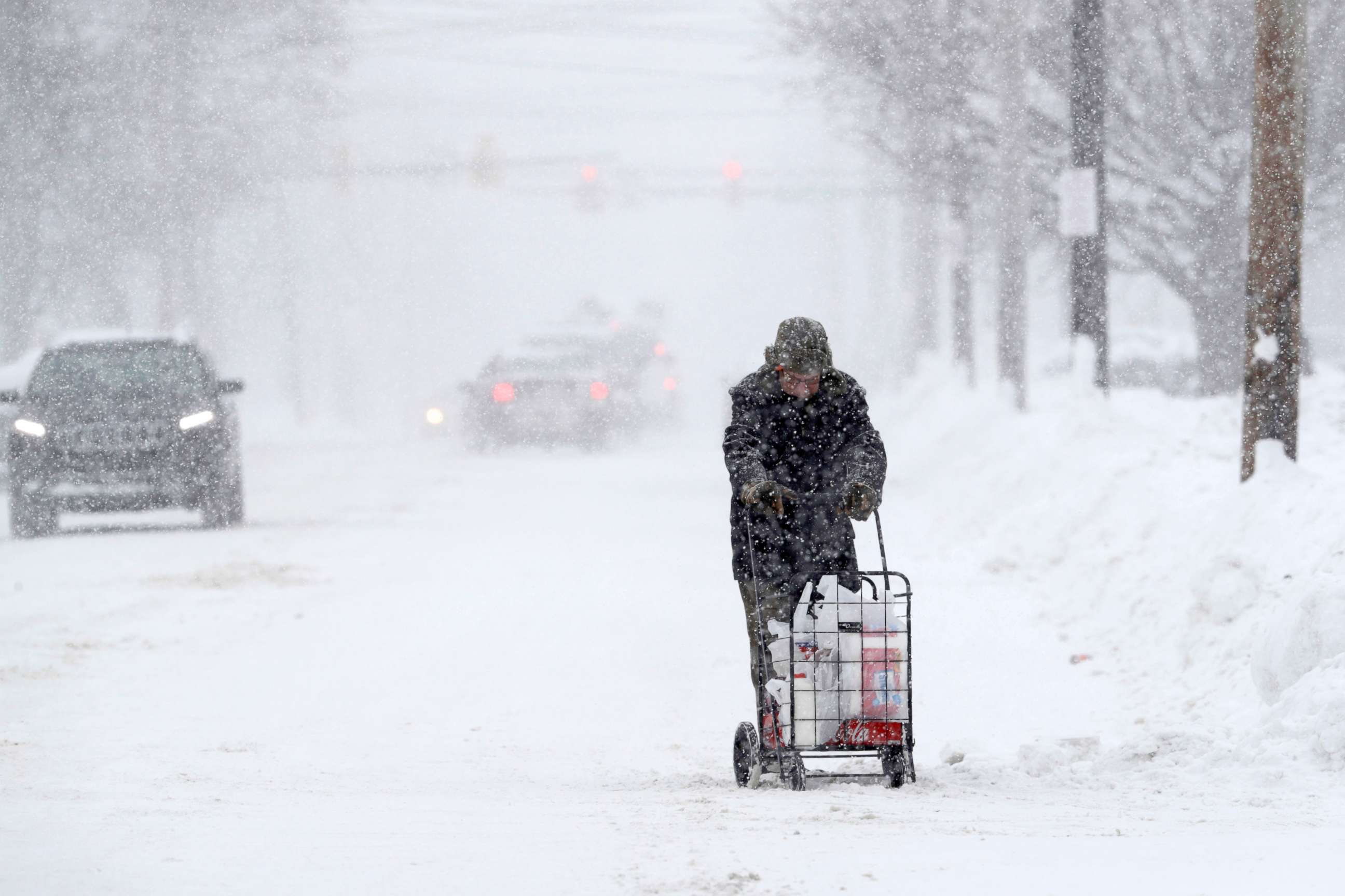 PHOTO: A man walks with his groceries in a cart during a heavy snowfall, Dec. 29, 2017, in Erie, Pa. 