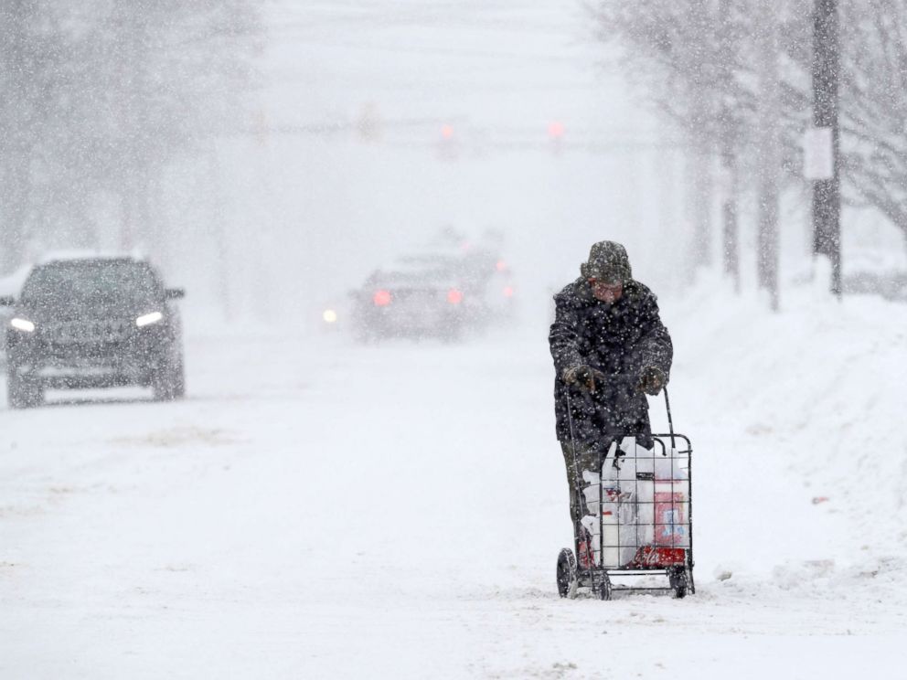 PHOTO: A man walks with his groceries in a cart during a heavy snowfall, Dec. 29, 2017, in Erie, Pa.