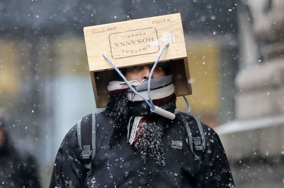 PHOTO: A pedestrian wearing an unusual hat walks through the snow as a blizzard hits central London, March 2, 2018.