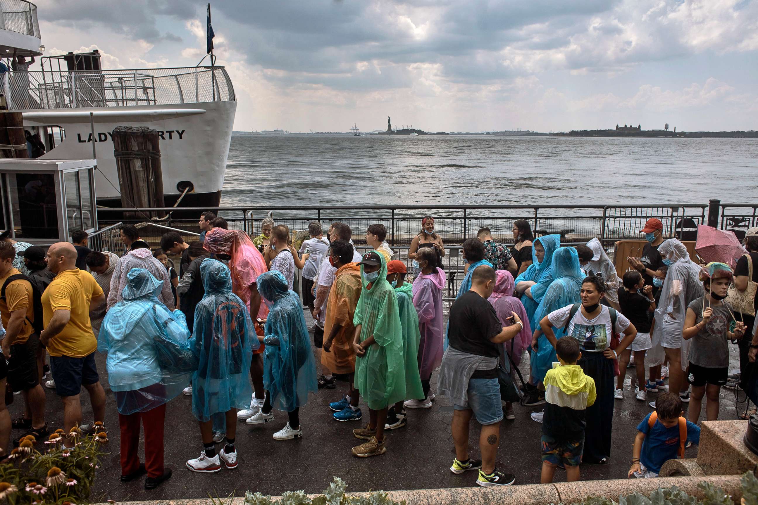 PHOTO: People wait to take a boat under the rain during a summer heat wave, Thursday, July 21, 2022, in New York.