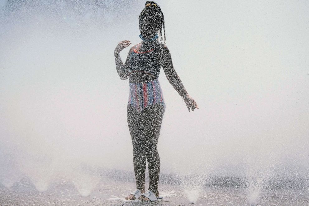 PHOTO: A girl cools off in the Salmon Street springs fountain in Portland, June 28, 2021.