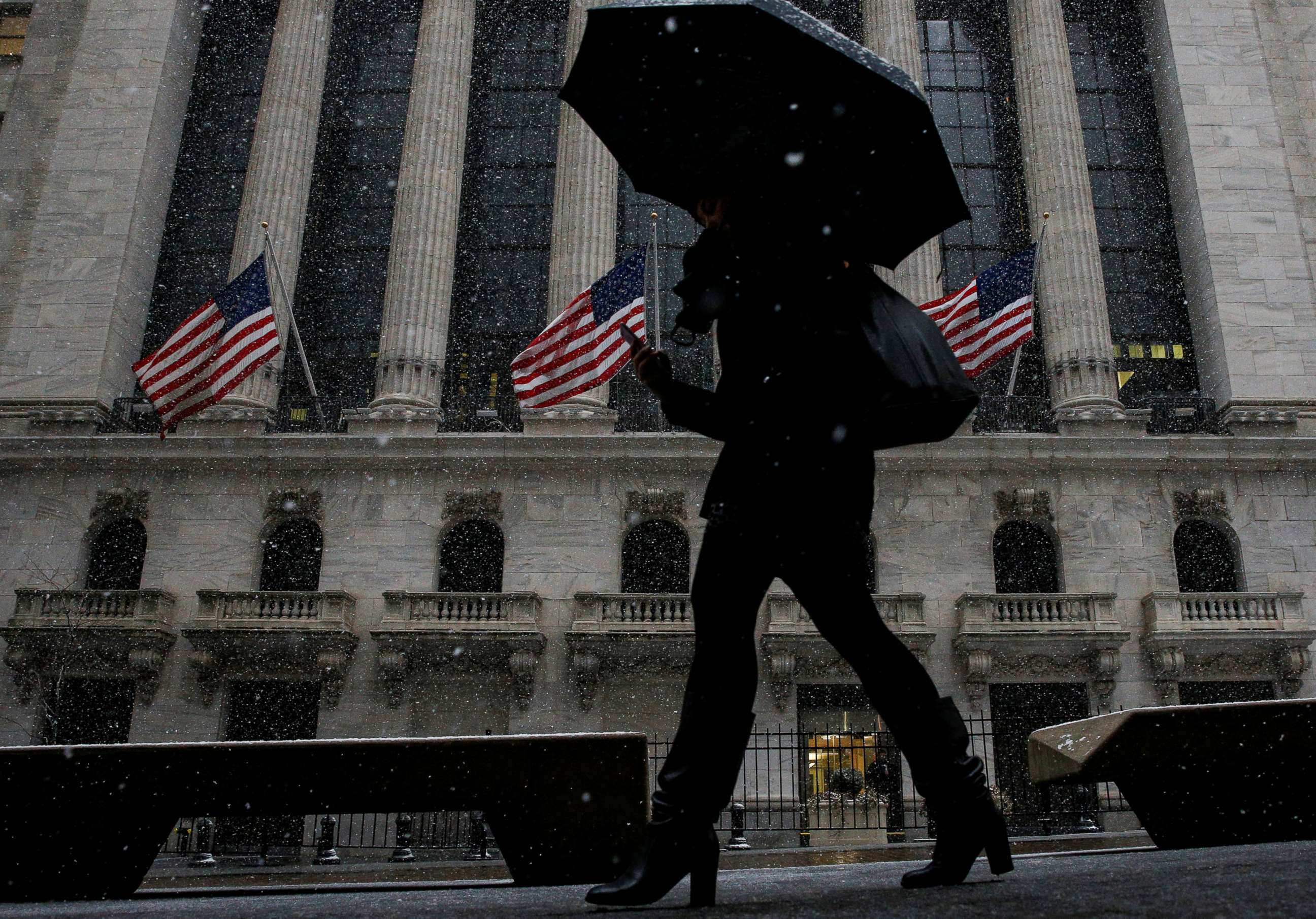 PHOTO: Snow begins to fall as morning commuters pass by the New York Stock Exchange,  in New York, Feb. 7, 2018.