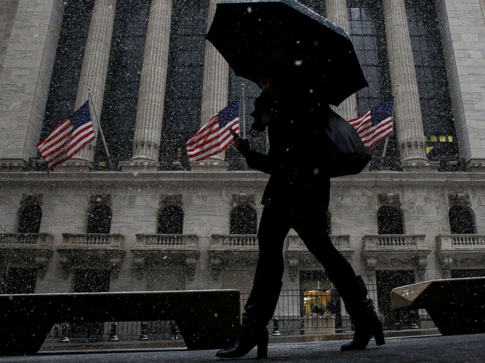 PHOTO: Snow begins to fall as morning commuters pass by the New York Stock Exchange, in New York, Feb. 7, 2018.