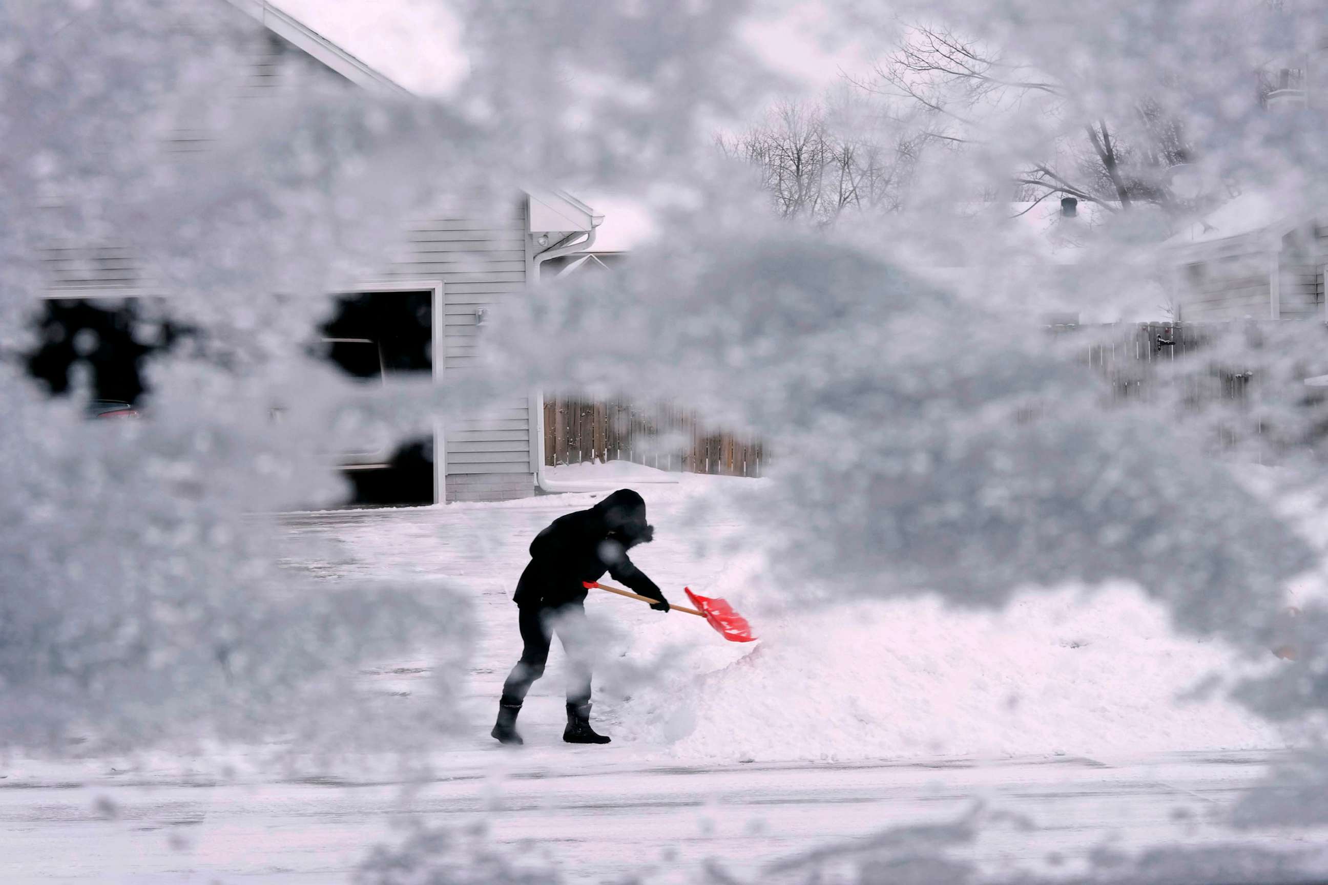 PHOTO: A local resident shovels snow off the end of a driveway, Dec. 22, 2022, in Urbandale, Iowa.