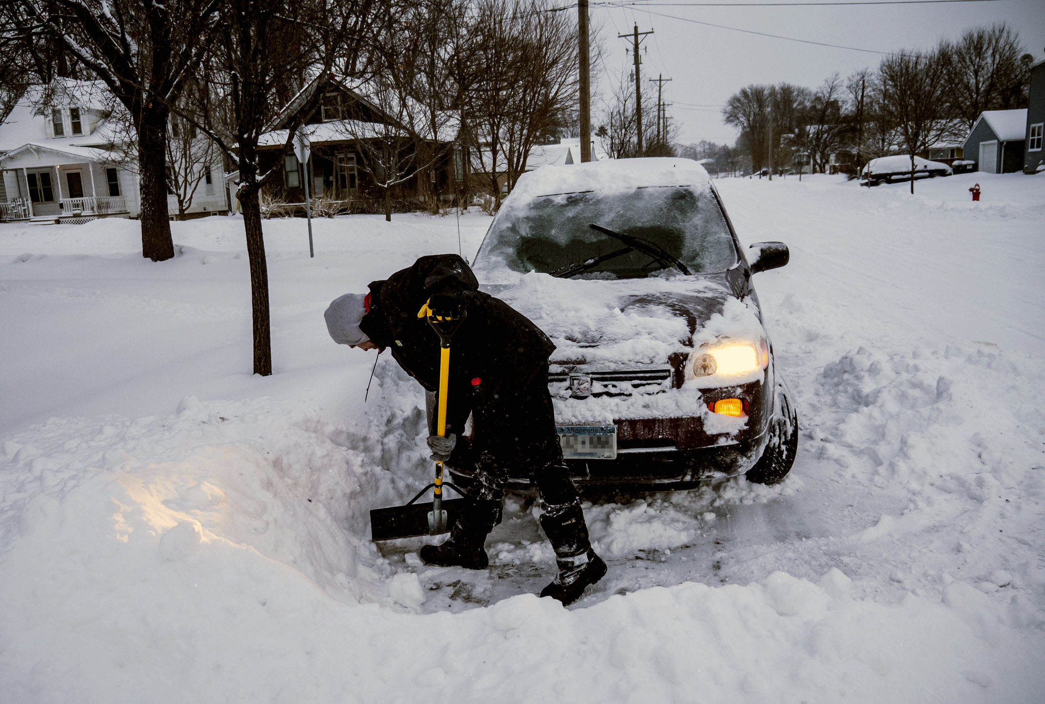 PHOTO: Adam Fischer shovels out his vehicle to go to work, Jan. 28, 2019, in Rochester, Minn.