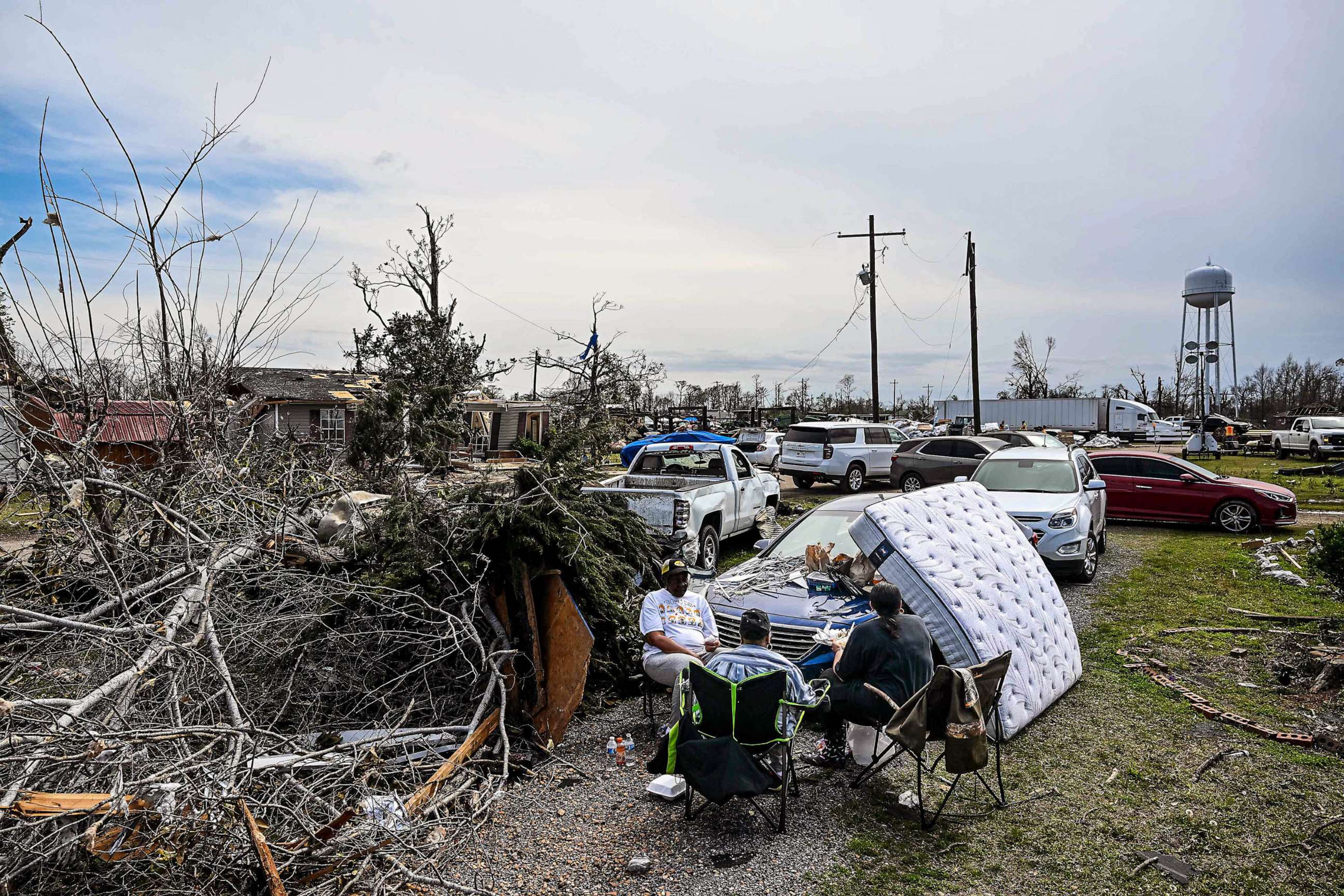 PHOTO: Earnestine Hilu sits with family members outside her destroyed house in the aftermath of a tornado in Silver City, Miss., March 26, 2023.