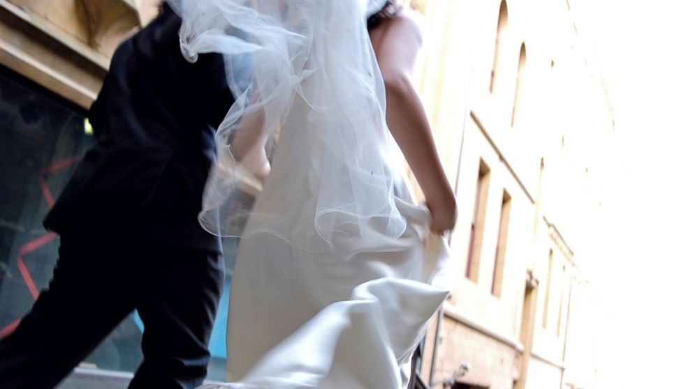 PHOTO: Bride and groom is running side by side in this stock image.
