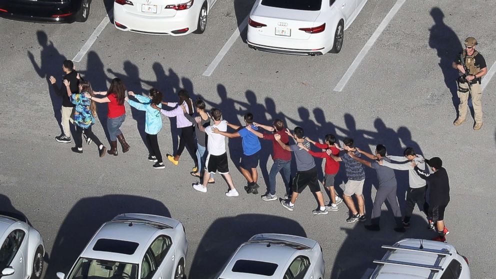 People are brought out of the Marjory Stoneman Douglas High School after a shooting at the school that reportedly killed and injured multiple people on Feb. 14, 2018, in Parkland, Fla.